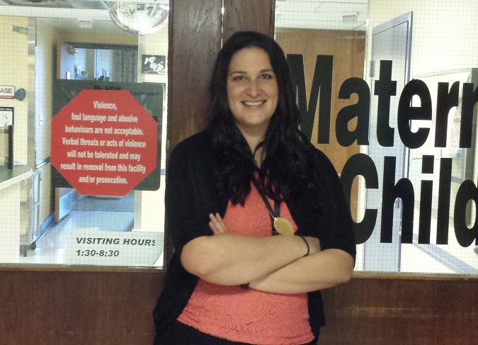 St. Joseph's Hospital Foundation's Katie Maximick poses in front of the doors to the Maternal Child Unit in St. Joseph's Hospital, where she was born.